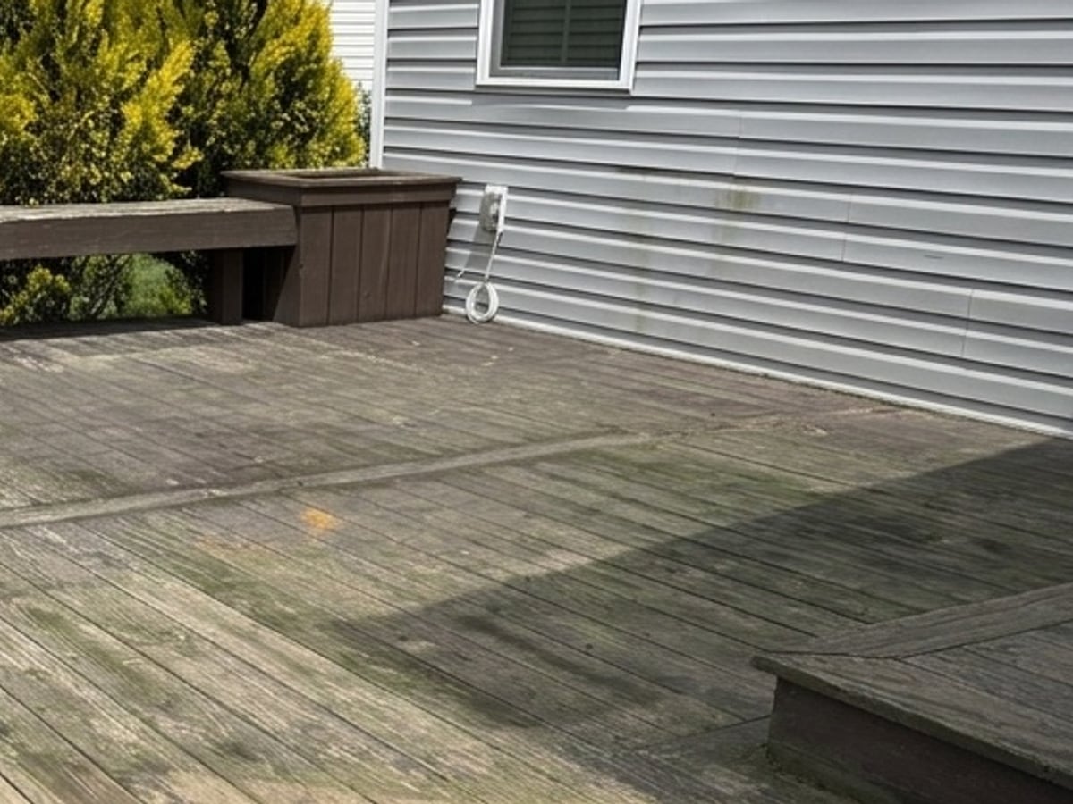 Before, a weathered grey deck with green algae and worn boards