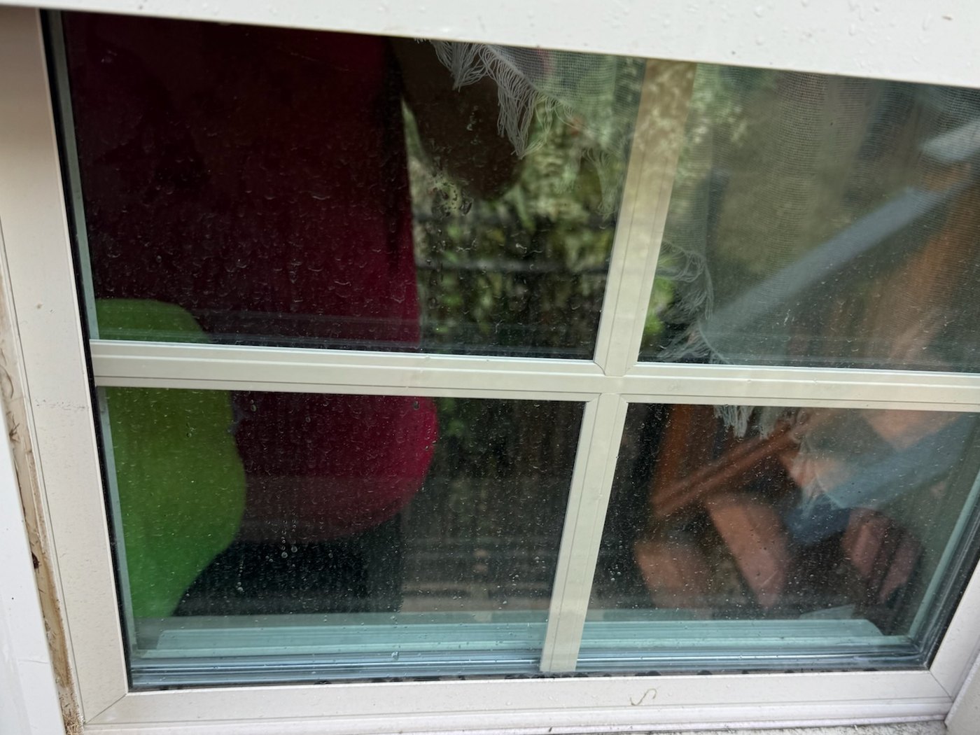 Before, the same window with a dirty film on the glass and grime built up along the sill