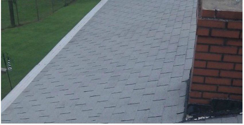 After, the same asphalt shingle roof soft washed clean of algae streaking