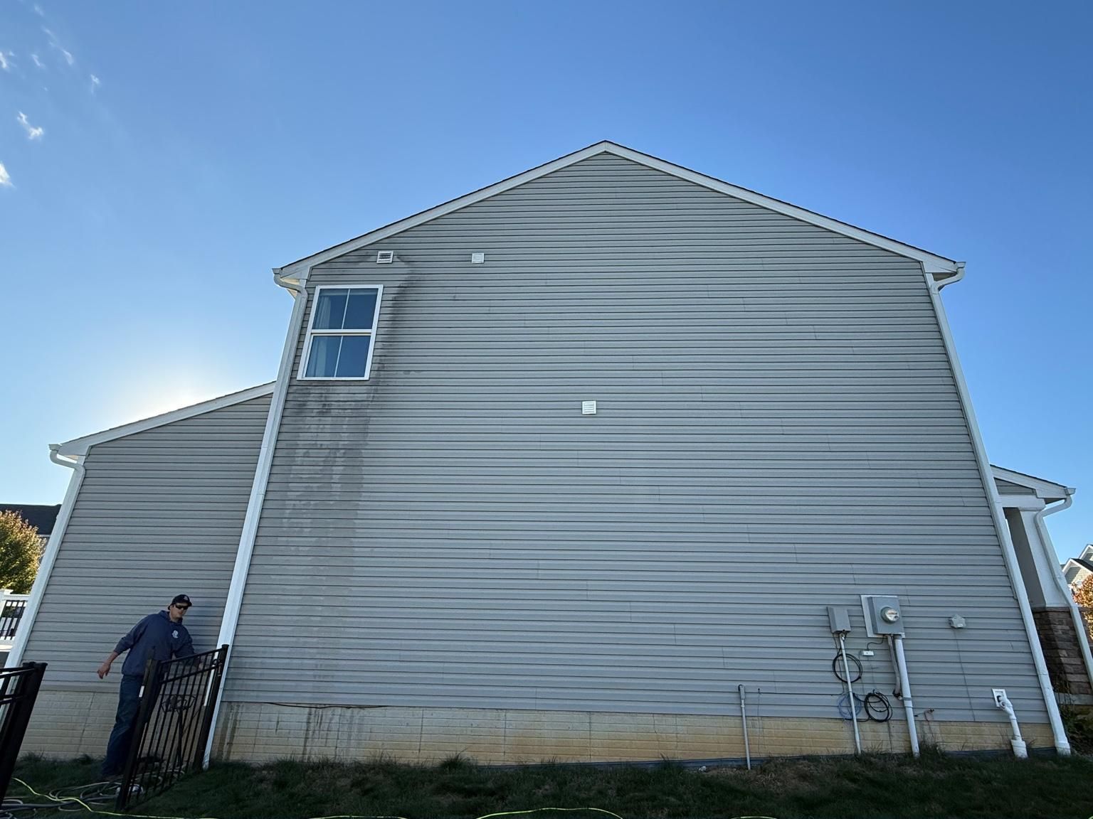 Before, vinyl siding with heavy algae streaking down from the roofline