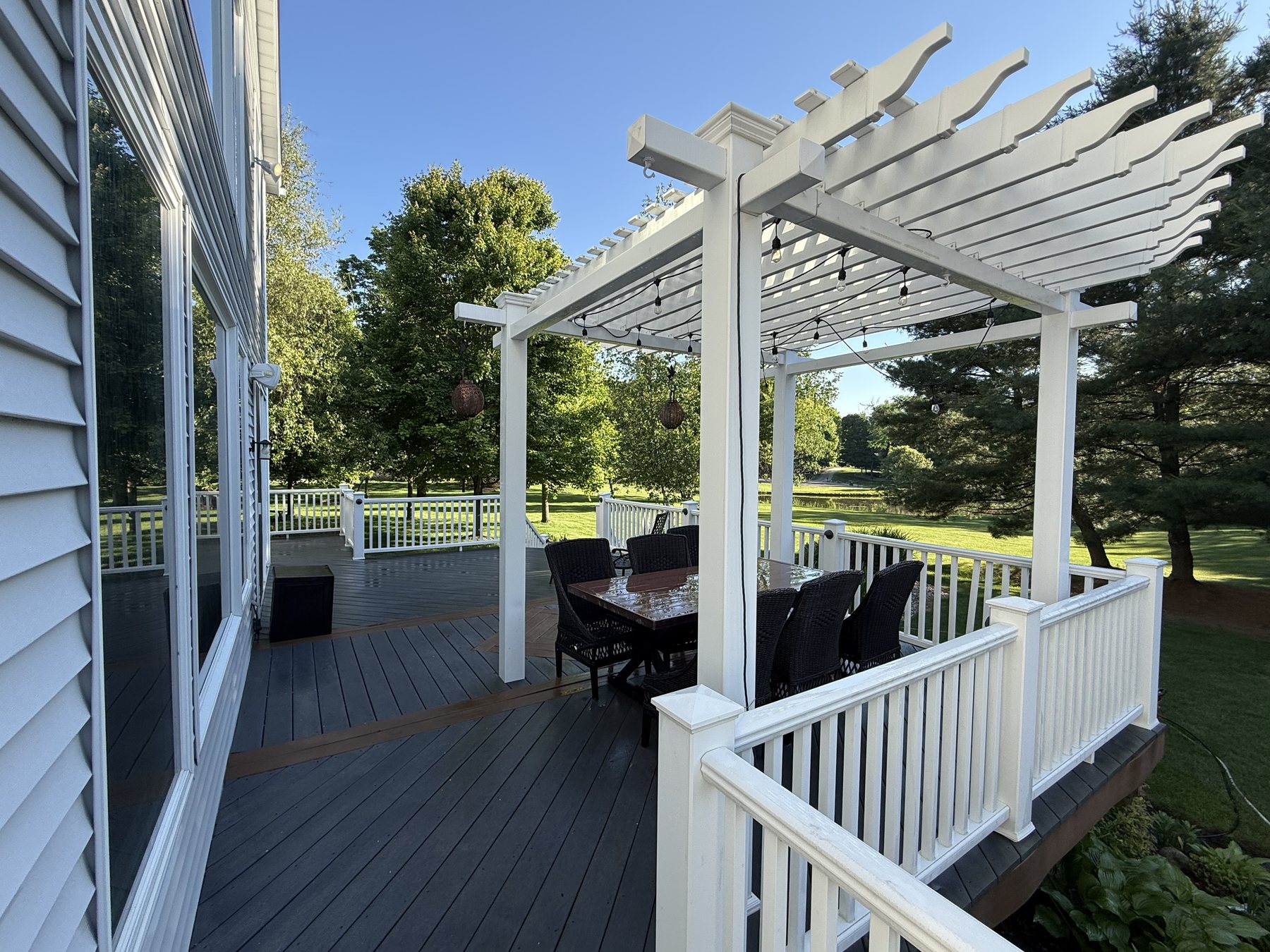 A cleaned deck and white pergola by Core Exterior Services
